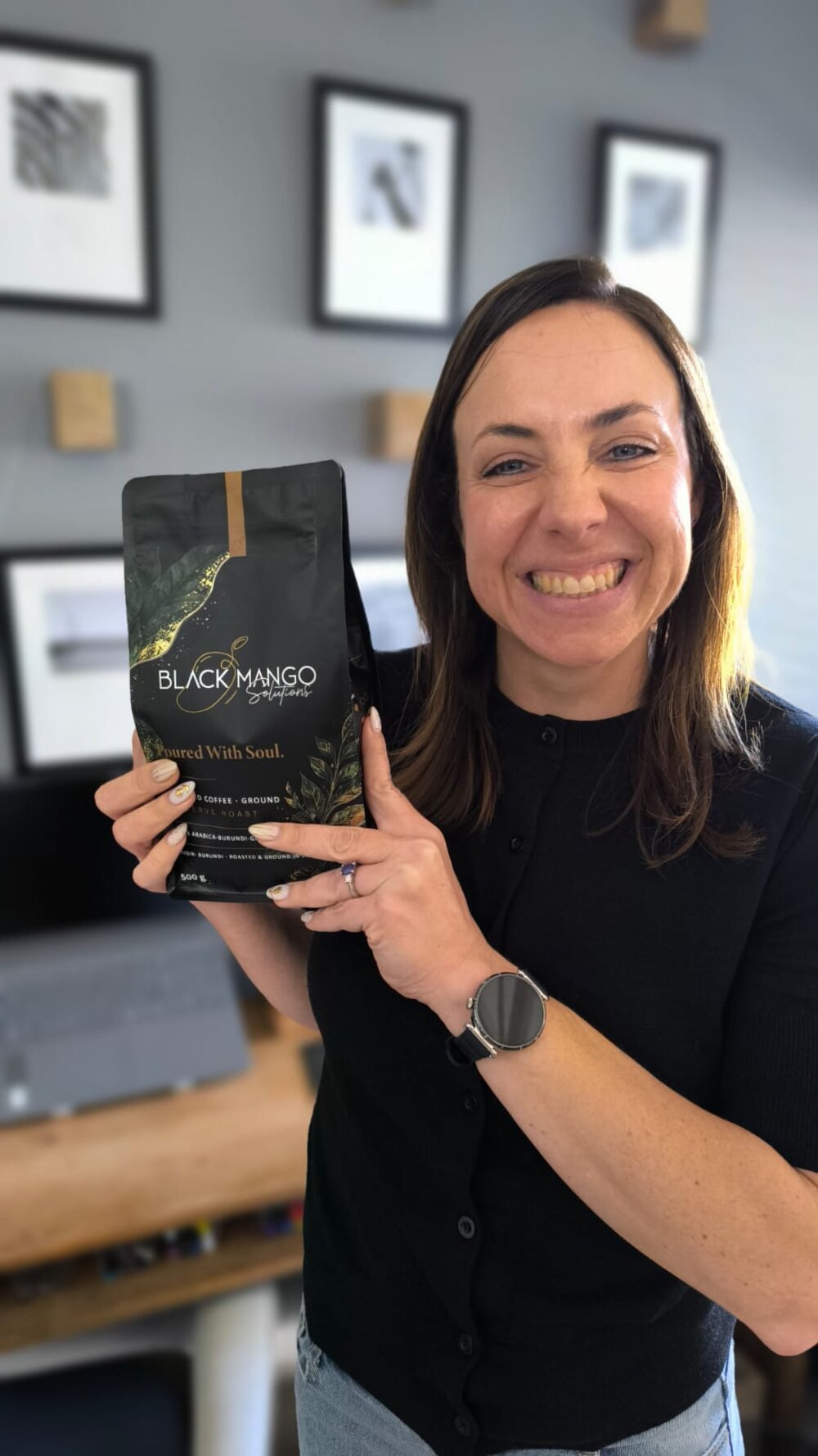Adél from Black Mango Solutions Accounts with a bag of Black Mango coffee