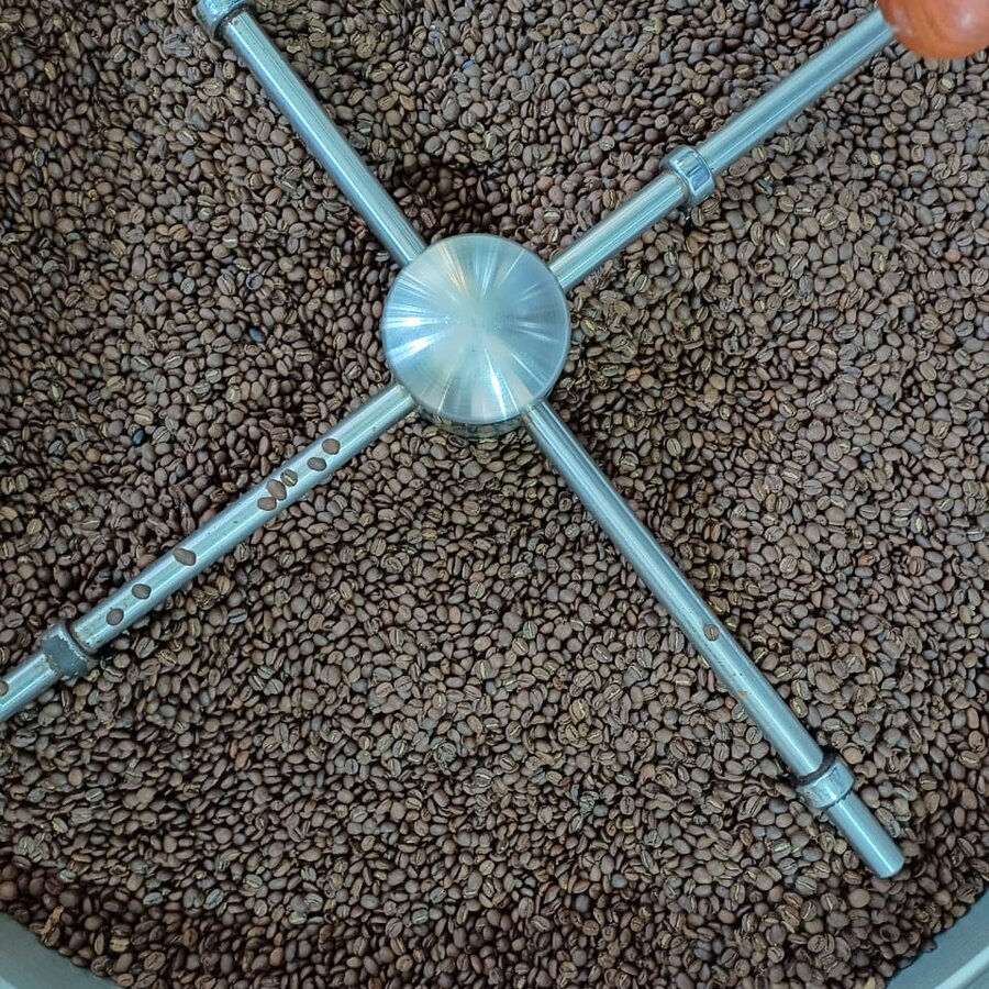 Green coffee beans turning in the roaster drum